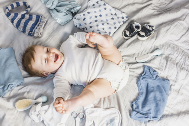 top view blonde baby surrounded by clothes 23 2147983486 - 4